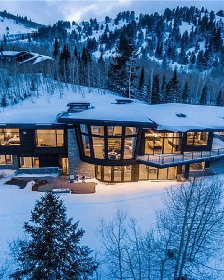 Modern home lit at blue hour in fresh snow