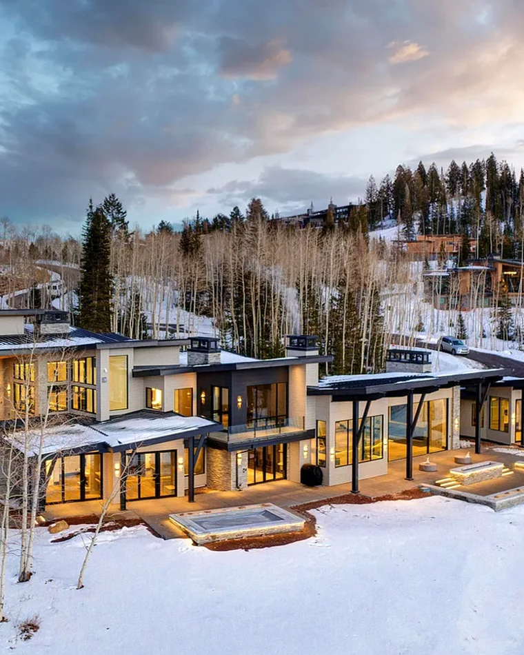 Contemporary mountain home at twilight above snowy aspens