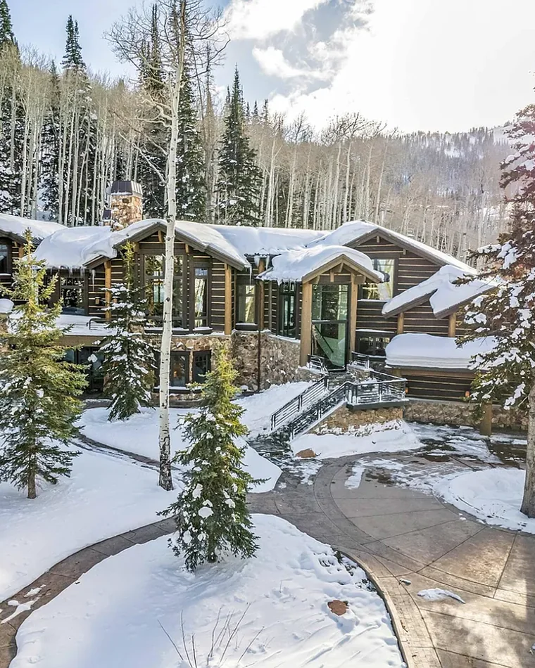 Snow-covered lodge among firs and aspens