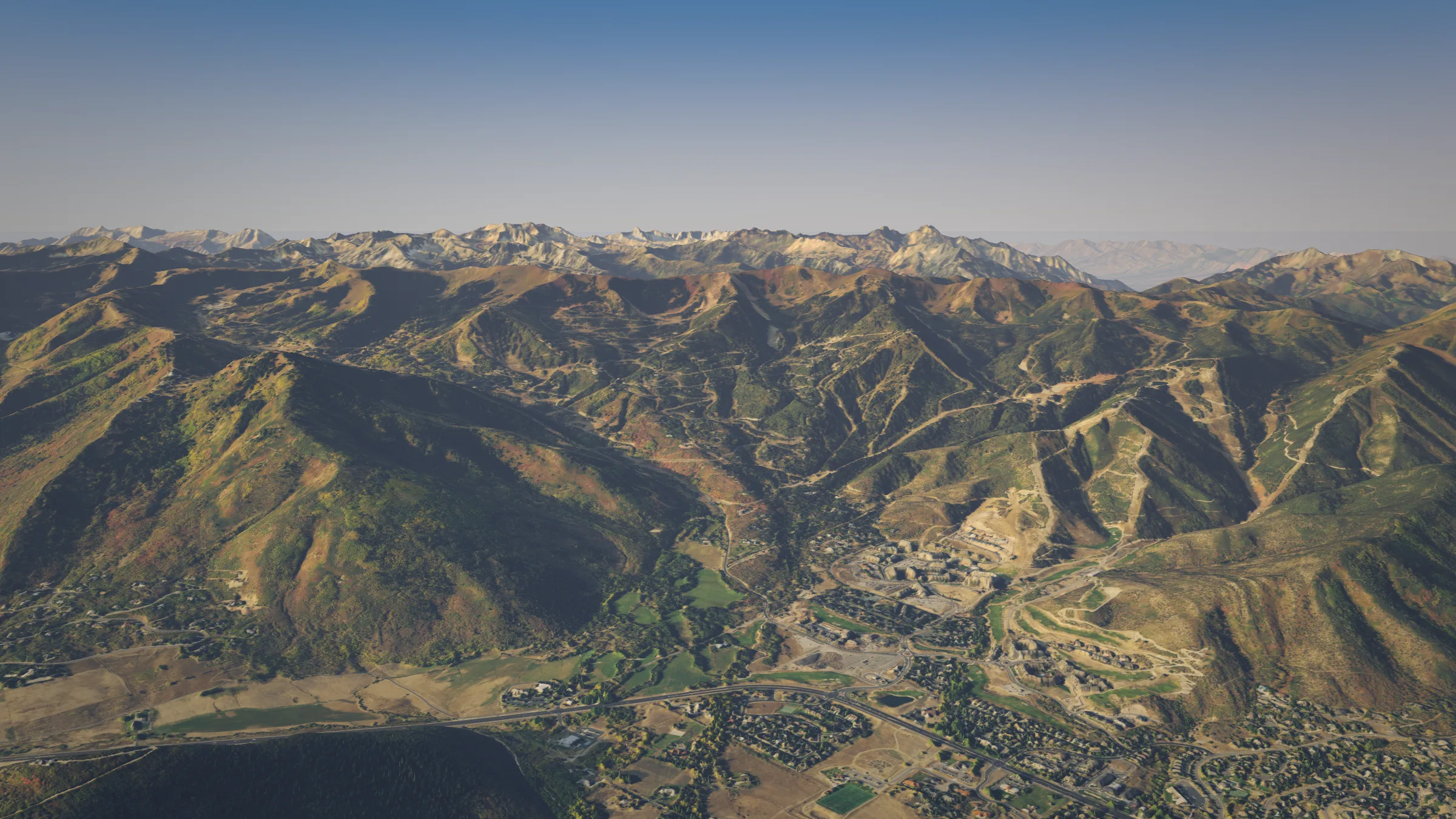 Sunrise aerial looking up White Pine Canyon from above Canyons Village, with The Colony on the slopes below the Wasatch peaks
