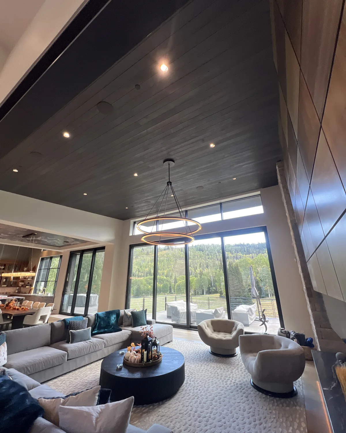 Great room with walls of glass looking into aspens