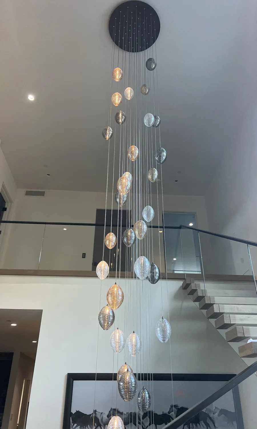 Floating oak staircase with a cascading glass chandelier